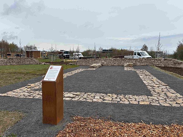 Kalkstein-Trockenmauer mit rechteckiger Vorfläche mit Kalksteinrand und kleinen grauen Steinen