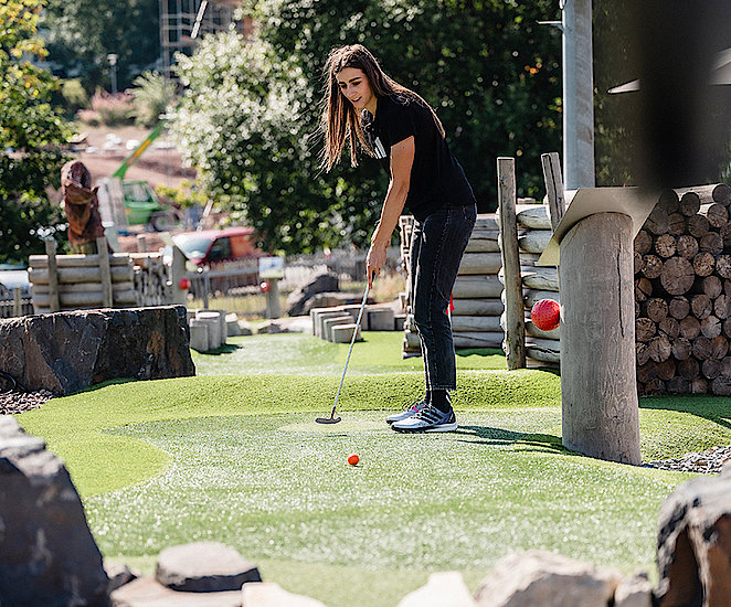 Vanessa Voigt spielt eine Bahn AdventureGolf.