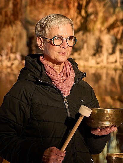 Andrea Röttig in der Feengrotte mit einer Klangschale in der Hand