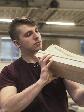 Ein Mitarbeiter von Treppen Schmidt bearbeitet eine Holzplanke an einer Fräsmaschine