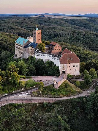 Wartburg Eisenach UNESCO Welterbe in Thüringen: Wartburg Eisenach auf einem Hügel in Waldlandschaft