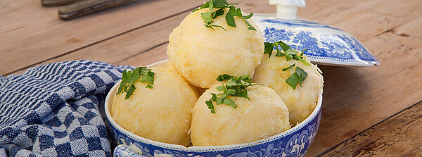 Klöße in einer blauweiß-gemusterten Porzellanschüssel mit angelegtem Deckel