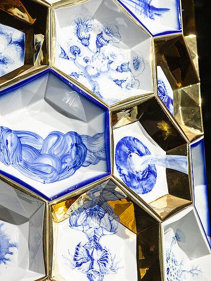 Kunstobjekt zusammengesetzt aus sechseckigen blau-weiß-gold bemalten Porzellanschüsselchen