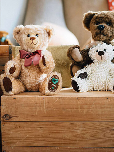 Märtin Bären in verschiedenen Größen und Fellbrauntönen sind zur Ausstellung arrangiert auf Holzkisten und in Regalen