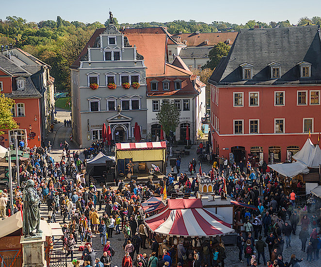  Ein Blick von oben auf den Marktplatz von Weimar während de Zwiebelmarktes. Zwischen Besucher sind Zelte und eine Bühne aufgebaut.