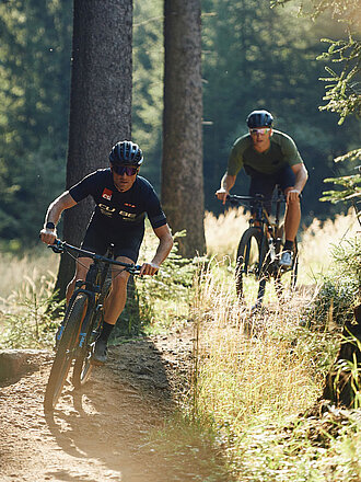 Zwei Mountainbiker fahren quer durch den Thüringer Wald