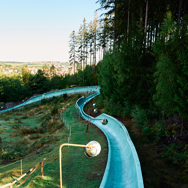 Wir sehen ein Bild der Ilmenauer Rodelbahn von oben, Die Bahn hinunter ins Tal.